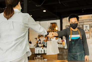 Woman and man with mask at a restaurant delivering food