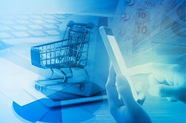 hand using phone and shopping cart on computer