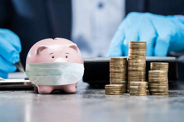 piggy bank with mask and man in background on a suit with gloves and pile of coins