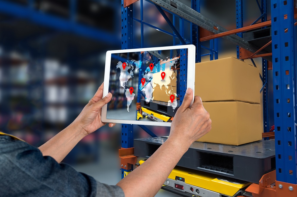 Worker's hand with tablet with a map following packages