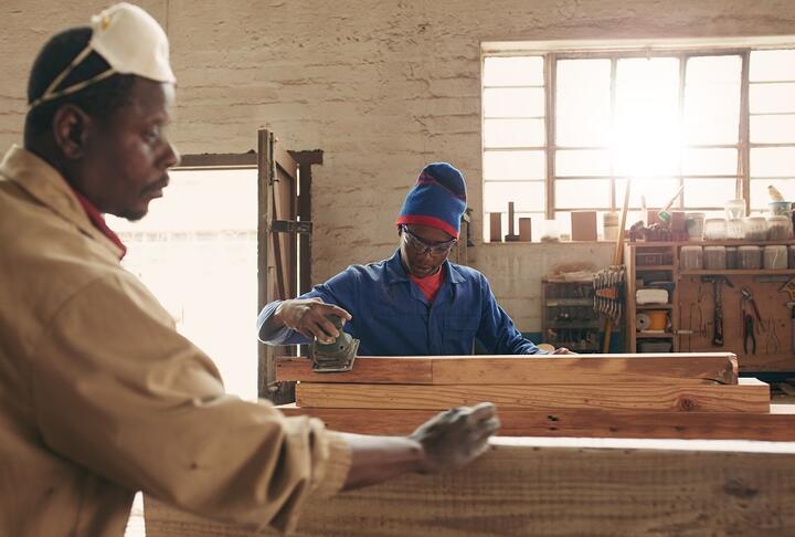 African man with a mask working a workshop