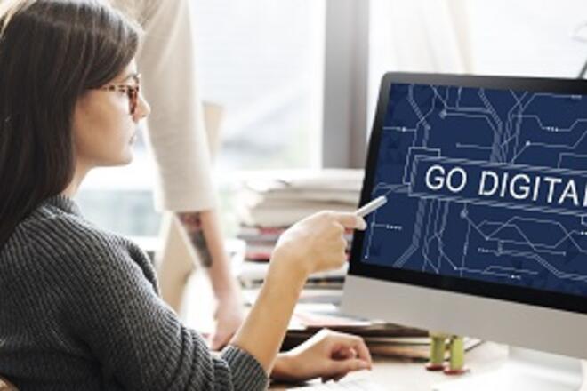 Woman in front of computer monitor point at the screen with legeng: Go Digital