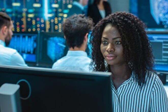 African woman sitting in front of computer analyzing data