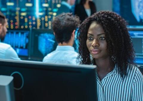 African woman sitting in front of computer analyzing data