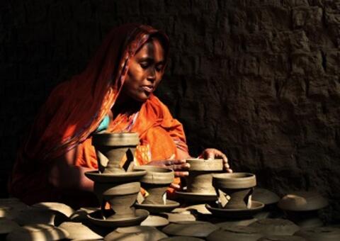 An entrepreneur in Bangladesh puts the finishing touches on her clay pots. Photo: Moksumul Haque, 2015 CGAP Photo Contest